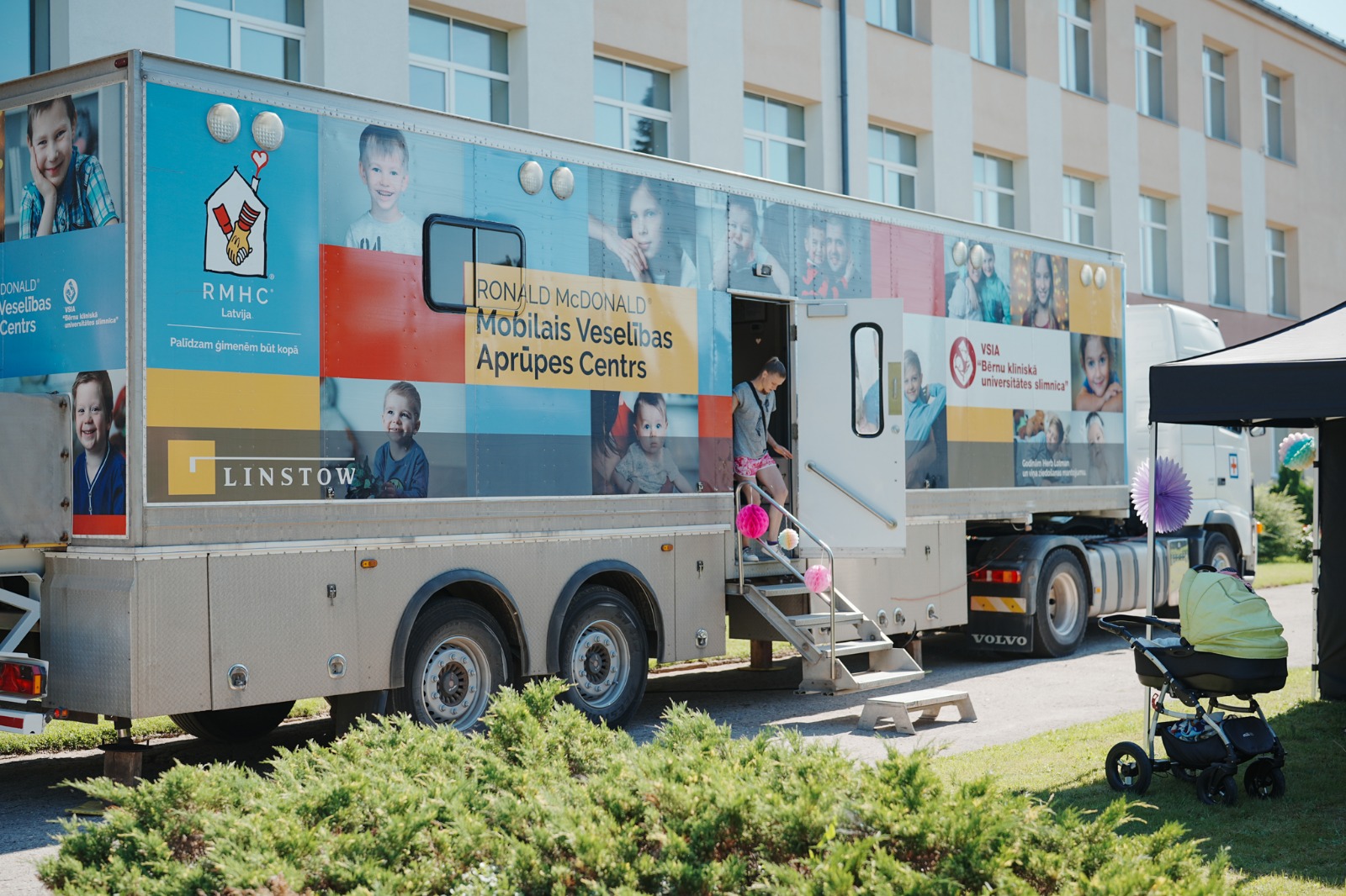 Madonas novada ģimenes bērnu veselības aprūpe mobilajā veselības aprūpes centrā RMHC pie skolas ēkas, nodrošinot bezmaksas ārstu konsultācijas ģimenēm.